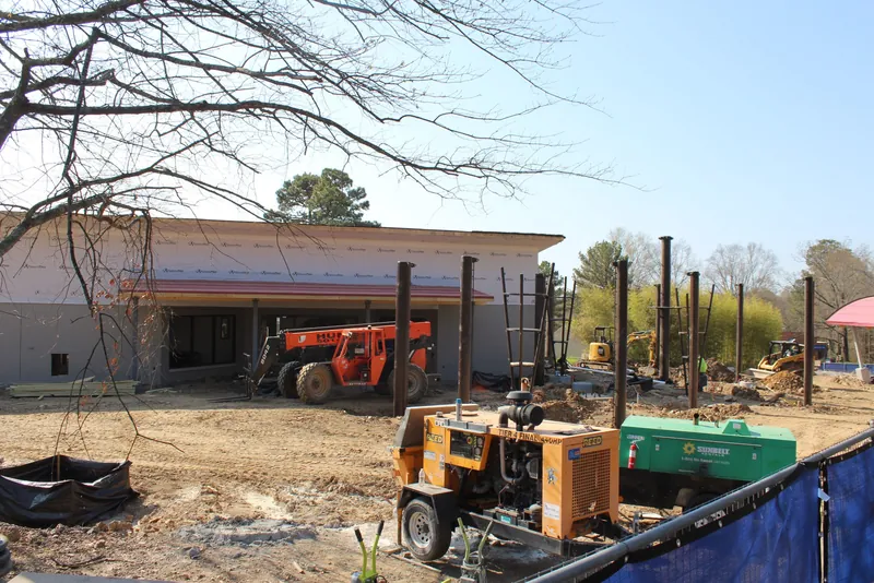 Construction machinery working beside a partially completed habitat structure at the Zoo